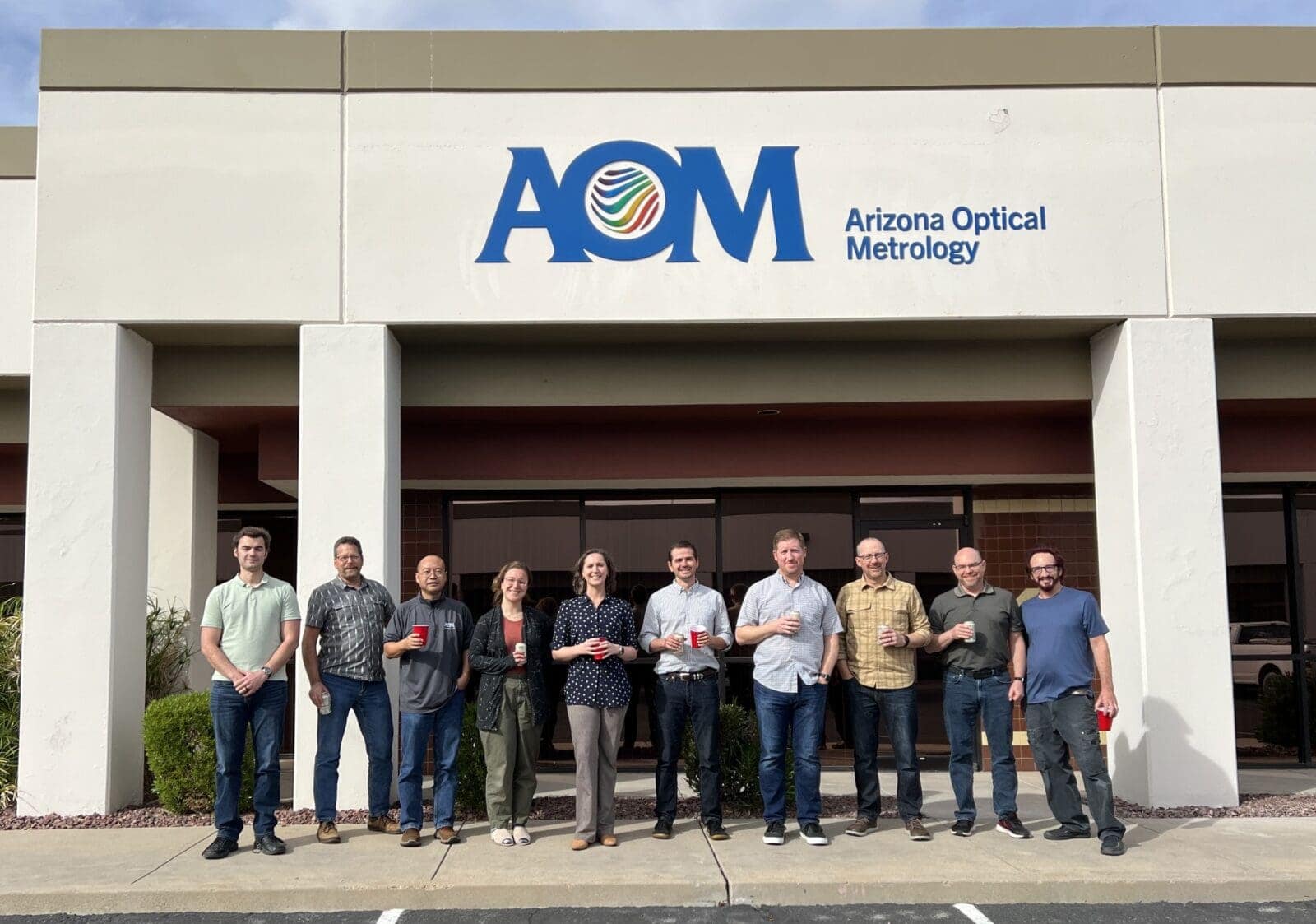 The AOM team poses in front of the Tucson office.